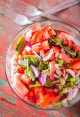 Fresh tomatoes with onion and lettuce in bowl