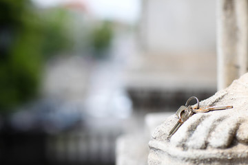 Schlüssel am Fuß einer Skulptur