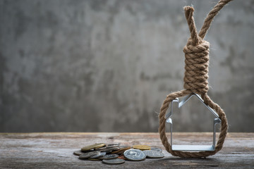 Fototapeta premium Hangman's noose with house and money on brown wooden surface