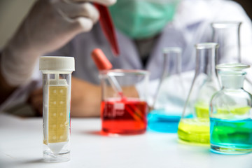 Laboratory research, lab glassware containing chemical with blur scientist 