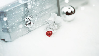 Obraz na płótnie Canvas Christmas angel with a heart box with a gift selective snow soft focus