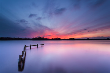 Blue Sunset over Tranquil Lake with Wooden Mooring Post