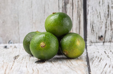 Calamansi citrus over weathered wooden background
