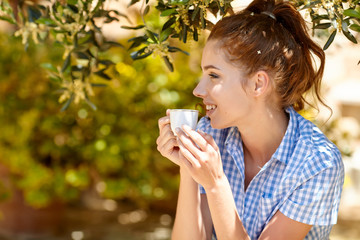 Woman drinking morning coffee in the garden