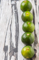Calamansi citrus over weathered wooden background