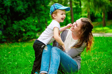 Cute cheerful child with mother play outdoors