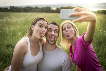 happy friends spending free time together in a field