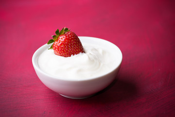 Strawberry in a bowl with cream