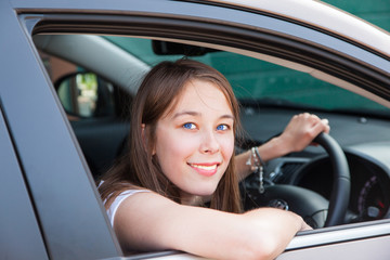 Fototapeta na wymiar Teenage girl drives in a car