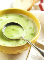 Cream soup with potato and green peas. Selective focus