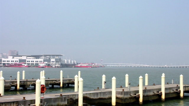 Empty mooring posts at Macau Fisherman's Wharf and view of Outer Harbour Ferry Terminal with ferries