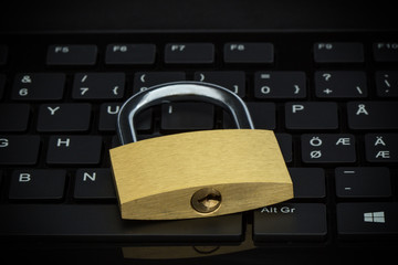 Close-up of a locked padlock on a computer keyboard. Concept photo of computer security.