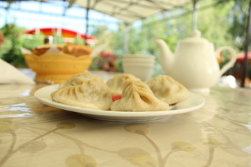 Asian national food (Manty) on the table in outdoor cafe.