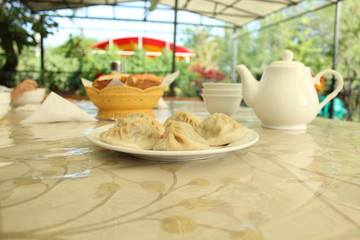Asian national food (Manty) on the table in outdoor cafe.
