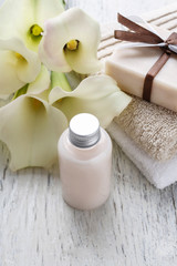Obraz na płótnie Canvas Bar of handmade natural soap, liquid soap, towels and bouquet
