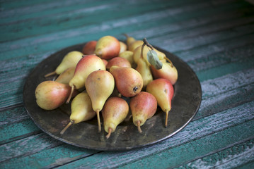 Fresh pears on a tray, rustic wooden background