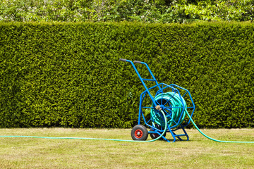 Blue heavy duty garden hose reel on a lawn