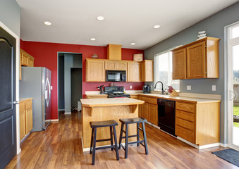Small kitchen with red and gray walls.