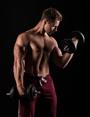 Fototapeta na wymiar Handsome power athletic man with dumbbell confidently looking fo