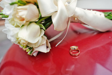 wedding bouquet on red background with rings