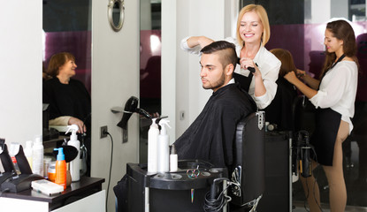 Woman hairdresser doing hairstyle