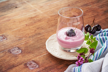 Cherry yogurt and ripe cherry with a sprig of marjoram