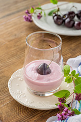 Cherry yogurt and ripe cherry with a sprig of marjoram