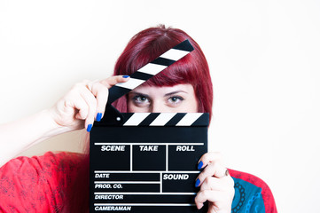 Young woman smiling showing movie clapper board