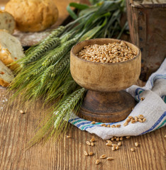 Ears of barley and wheat on the wooden background