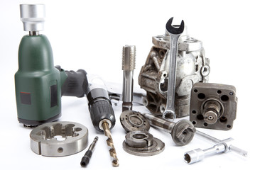 Car repair - details of the pump of high pressure and air impact wrench on white background