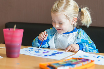 Kleines Mädchen malt mit Wasserfarben