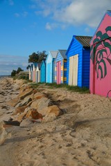 Coloured Boat sheds on beach.