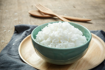 Bowl of Organic White Rice with wooden spoon & fork - soft focus