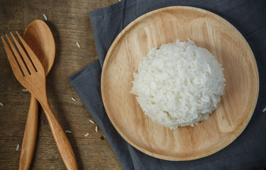 Cooked rice with a spoon and fork on wooden table - soft focus