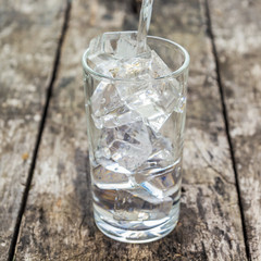 Pour water into a glass of ice