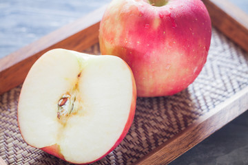 Red apple on wooden tray