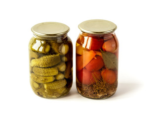 Salted cucumbers and tomatoes in glass jars isolated on white