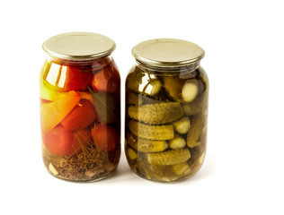 Salted cucumbers and tomatoes in glass jars isolated on white
