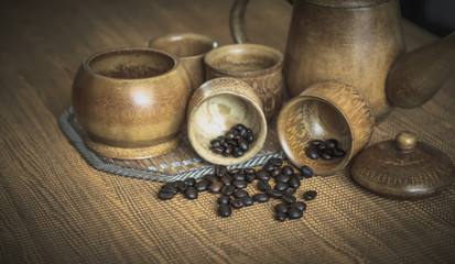 Vintage photo of coffee beans and Coffee cups set on wooden back