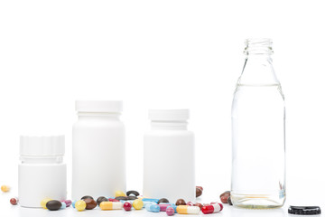 Bottle of water, rx bottle and colorful pills on white