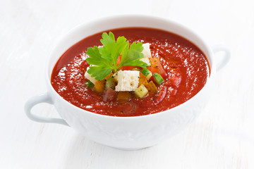 fresh gazpacho with croutons in a bowl on white table