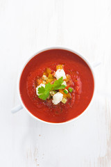 fresh gazpacho with croutons in a bowl, top view, vertical