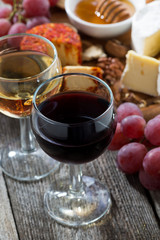 glass of white and red wines, appetizers on a wooden table