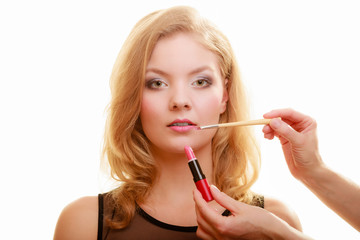 Makeup. Woman applying red lipstick with brush