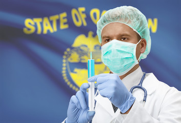 Doctor with syringe in hands and US states flags on background series - Oregon