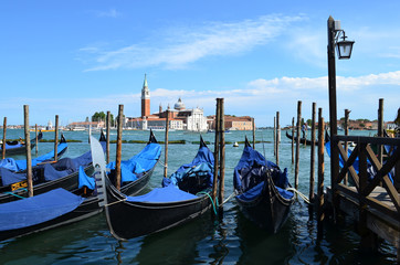 Naklejka na ściany i meble Venetian gondolas on the background of the Cathedral of San Giorgio Maggiore 