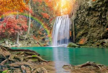 Wonderful Waterfall with rainbows and red leaf in Deep forest at