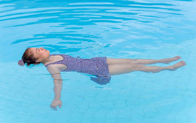 Young woman with swimsuit in swimming pool.