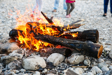 Family enjoying time by the river and self-made campfire