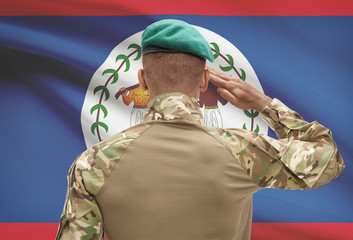 Dark-skinned soldier with flag on background - Belize